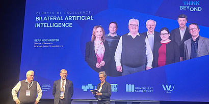 Bilateral AI is presented on stage with an image of the BilAI Board of Directors.