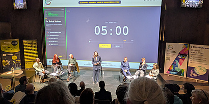 The group debate on stage, discussing about to ban or not to ban AI in Higher Education.