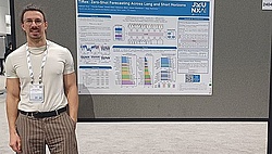 Researcher at NEURIPS, standing in front of a scientific poster.